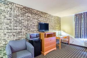 a living room with a tv and a chair at Motel 6-Grand Rapids, MI - Northeast in Grand Rapids
