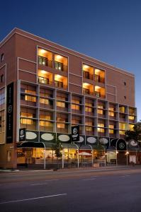 a large building with lights on in a street at Adelaide Riviera Hotel in Adelaide