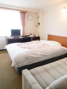 1 dormitorio con 1 cama y escritorio con ordenador en Hikone Station Hotel, en Hikone