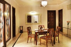 a dining room with a table and chairs and a mirror at Perch Arbor Suites in Gurgaon