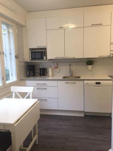 uma cozinha com armários brancos e um lavatório em City Apartment Snellmaninkatu 22 B em Kuopio