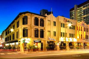 a building on the corner of a street at night at The Southbridge Hotel in Singapore