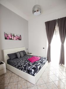 ein Schlafzimmer mit einem Bett mit einem rosa Kissen darauf in der Unterkunft B&B Feni in Pompei