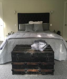 a bedroom with a bed with a trunk in front of it at Lye Bow Lake Suite in Alexandra