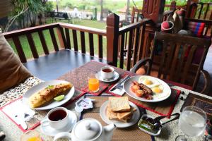 a table with two plates of breakfast food on it at Viang Yonok Hotel, Restaurant, Sports Club in Chiang Saen