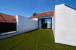 a room with a green lawn next to a house at Hotel Colvenier in Antwerp