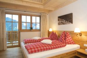 a bedroom with two beds with red and white pillows at Jausenstation Pfefferbauer in Zell am See
