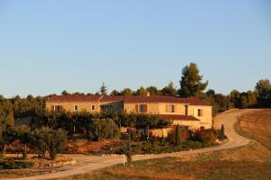 a house on a hill with a road leading to it at La Campagne de Petre in Entrevennes