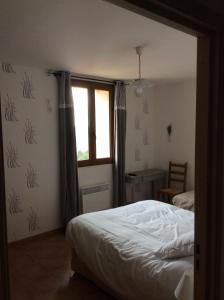 a bedroom with a bed and a window at La Campagne de Petre in Entrevennes