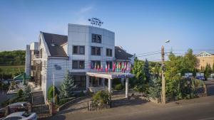 a white building with flags in front of it at Silver Hotel in Oradea