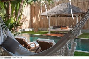 un par de hamacas frente a una piscina en 3BR Villa Rabu - Minggu Villas Seminyak, en Seminyak