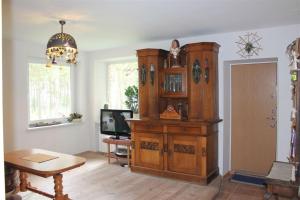 a large wooden cabinet in a living room with a television at Virgin'A in Nida