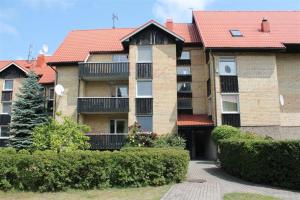 a large brick building with a red roof at Virgin'A in Nida