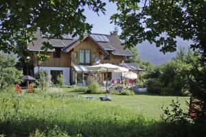 ein Haus mit Rasen davor in der Unterkunft Haus der Sonne in Kötschach