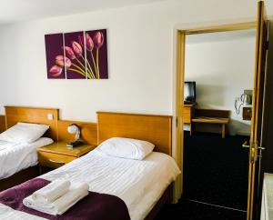 a hotel room with two beds and a mirror at The Beach Motel in Trearddur