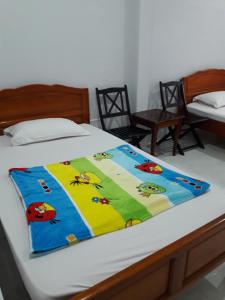 a bed with a colorful blanket on top of it at 247C/A Guest House in Mui Ne