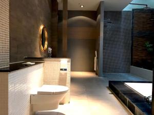 La salle de bains est pourvue de toilettes, d'un lavabo et d'une baignoire. dans l'établissement Fortune Villa Motel, à Tamsui
