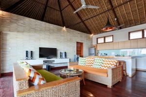 sala de estar con sofá y TV en Villa Agung, en Nusa Lembongan