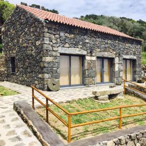 a stone house with a fence in front of it at Quinta do Fragoso in Alto do Sul