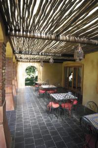 un patio con mesas y sillas en un restaurante en Casa Mia Health Spa and Guesthouse, en Addo