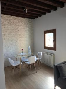 una sala da pranzo con tavolo, sedie e muro di mattoni di Apartamento Toledo Centro a Toledo