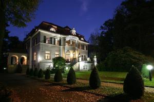 ein großes Haus in der Nacht mit eingeschaltetem Licht in der Unterkunft Aparthotel Villa Freisleben in Dresden