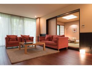 a living room with red furniture and a mirror at Auberge Suzukane in Koriyama