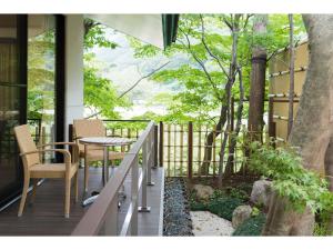 a porch with a table and chairs and a tree at Auberge Suzukane in Koriyama
