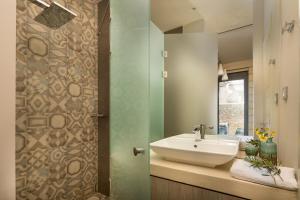 a bathroom with a sink and a mirror at Titans Villas in Kókkinon Khoríon