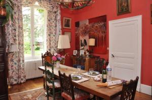 una sala da pranzo con pareti rosse e tavolo in legno di Château de La Villette ad Ardentes