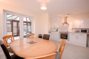 kuchnia i jadalnia z drewnianym stołem i krzesłami w obiekcie Town or Country - Jessie Terrace House B w Southampton