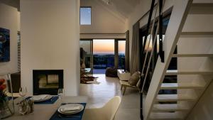 a living room with a dining table and a staircase at Willow Beach House - with backup power in Noordhoek