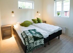 a bedroom with a large bed with green pillows at Ljugarn Semesterby in Ljugarn