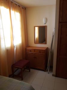 a bedroom with a dresser with a mirror and a chair at Apartamento Luz y Mar in Tazacorte