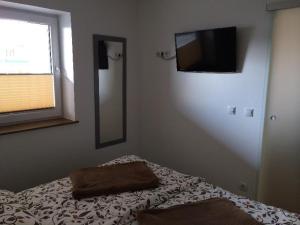 a bedroom with a bed and a flat screen tv at Moderne-Ferienwohnung-in-ruhiger-Lage in Quickborn