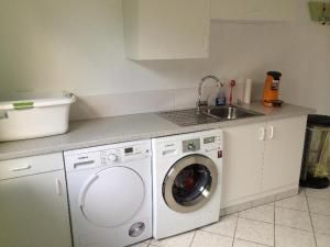 a kitchen with a washing machine and a sink at Moderne-Ferienwohnung-in-ruhiger-Lage in Quickborn +14 photos