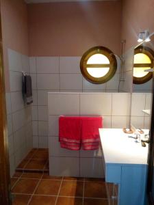 a bathroom with a sink and two red towels at Los Tobares in Gárgoles de Arriba