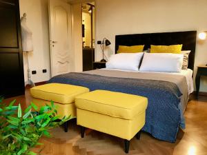 ローマにあるSweethome Crispiのベッドルーム1室(大型ベッド1台、黄色い椅子2脚付)