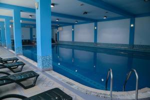 a swimming pool in a building with blue walls at City Mansion ApartHotel in Baku