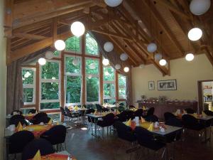 een eetkamer met tafels, stoelen en ramen bij alfa hotel in Sankt Ingbert