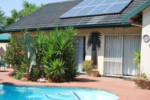 una casa con una matriz solar en el techo en Sleep Eezy Cottages, en Benoni