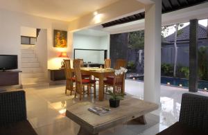 a dining room with a table and chairs at Samaja Beachside Villas in Seminyak