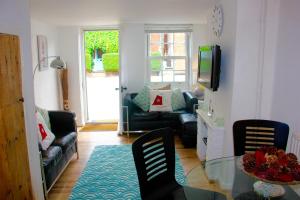 een woonkamer met een glazen tafel en stoelen bij Seaside Fisherman Cottage Southwold in Southwold