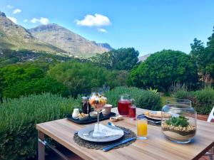 a table with food and drinks on it with mountains in the background at The Salt House in Hout Bay