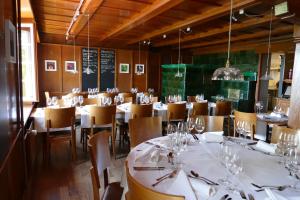 une salle à manger avec des tables et des chaises blanches dans l'établissement Gasthaus Schlosshalde, à Winterthour