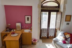 een kamer met een bureau, een wastafel en een raam bij Dimora La Rosa Barocca in Palazzolo Acreide