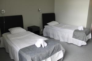 Habitación con 2 camas y toallas blancas. en Hotelli Kampeli en Veteli