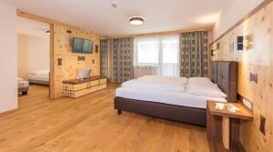 a bedroom with a large bed and a wooden floor at Hotel Garni Birkenhof in Sölden +40 photos