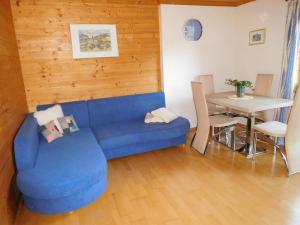 uma sala de estar com um sofá azul e uma mesa em Apartment Aschaber em Waidring