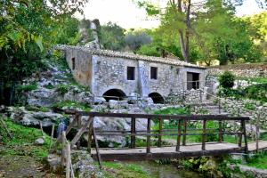 een oud stenen gebouw met een trap en een brug bij Dimora La Rosa Barocca in Palazzolo Acreide
